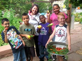 Children smiling with plants.